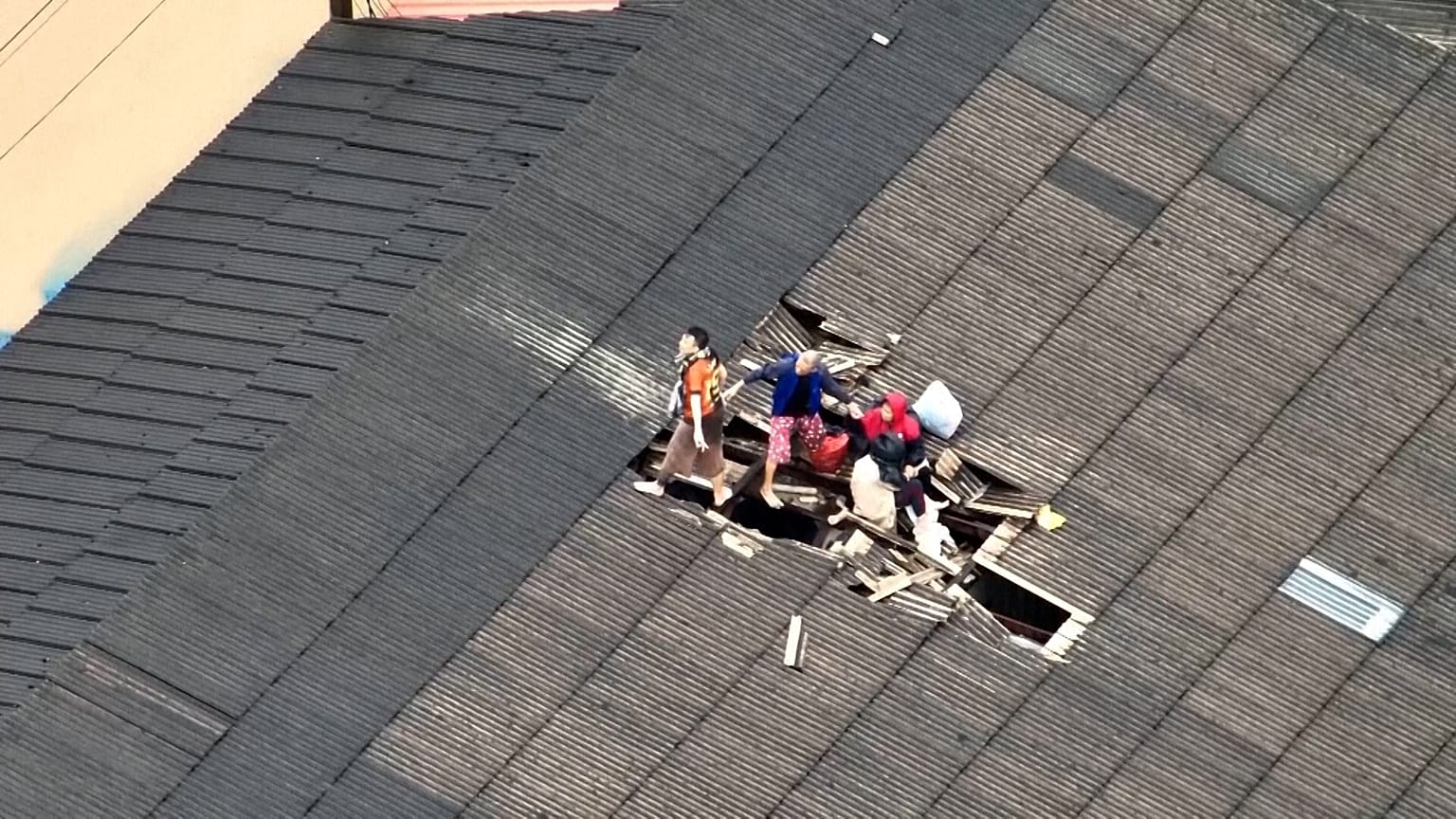 Una familia en la azotea de un edificio casi sumergido