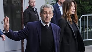 El expresidente francés Nicolas Sarkozy y su esposa, Carla Bruni-Sarkozy, salen de su domicilio el martes 21 de octubre de 2025.