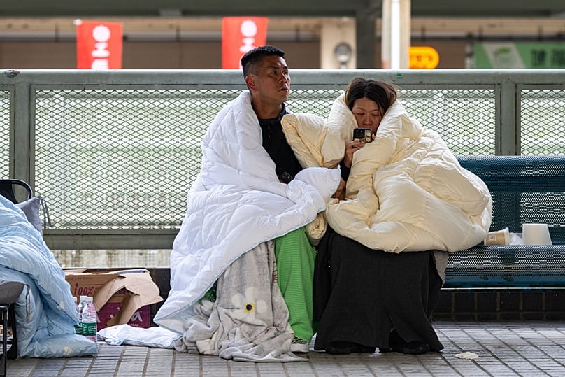 Residents rest at the fire scene at Wang Fuk Court, a residential estate in the Tai Po district of Hong Kong's New Territories, Thursday, Nov. 27 2025