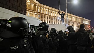Protester stands on top of a police vehicle as thousands took the streets of Bulgaria's capital, Sofia, to denounce steep taxes in next year's budget, Wednesday, Nov 26, 2025