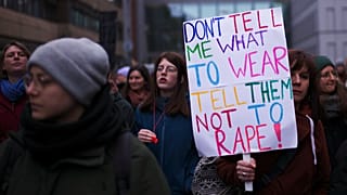 FILE - A woman shjows a poster as she attends a rally marking International Women's Day 2023 in Berlin, Germany, Wednesday, 8 March 2023.