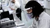 In Brasile, nel 2021: un dipendente al lavoro in un laboratorio.