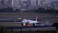 A TAP Air Portugal airplane lands at Lisbon airport as night falls, Friday, Aug. 26, 2022.