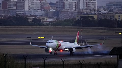 A TAP Air Portugal airplane lands at Lisbon airport as night falls, Friday, Aug. 26, 2022.