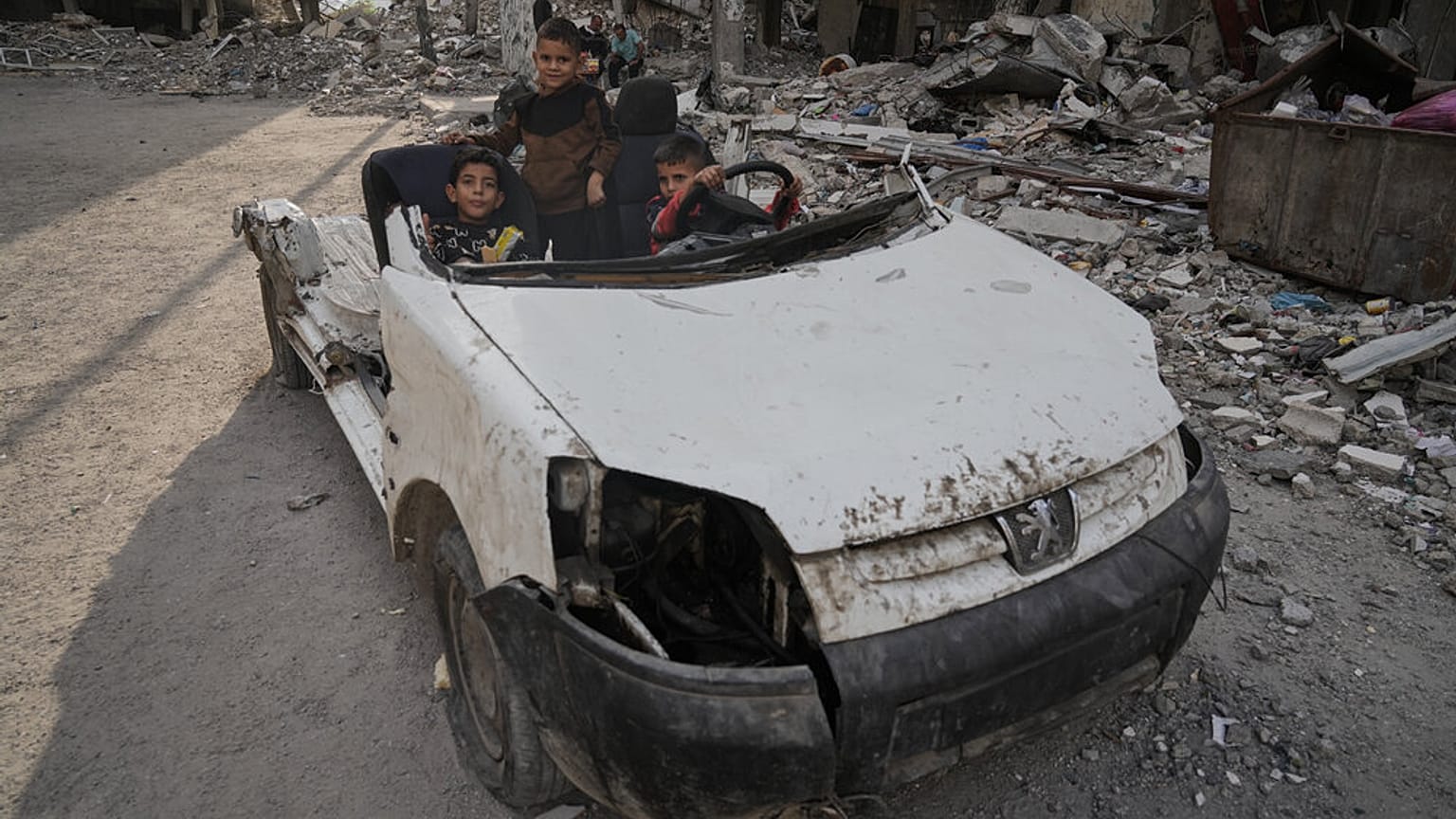 أطفال فلسطينيون يلعبون على سيارة مدمرة في مدينة غزة، يوم الاثنين 24 نوفمبر 2025. (تصوير: جيهاد الشرافي / أسوشيتد برس)
