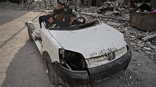 أطفال فلسطينيون يلعبون على سيارة مدمرة في مدينة غزة، يوم الاثنين 24 نوفمبر 2025. (تصوير: جيهاد الشرافي / أسوشيتد برس)