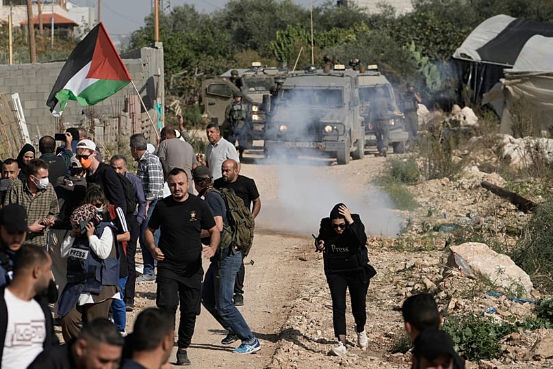 جنود إسرائيليون يفرقون محتجّين يطالبون بعودة الفلسطينيين النازحين إلى منازلهم في مخيم نور شمس بمدينة طولكرم في الضفة الغربية، في 23 نوفمبر 2025.