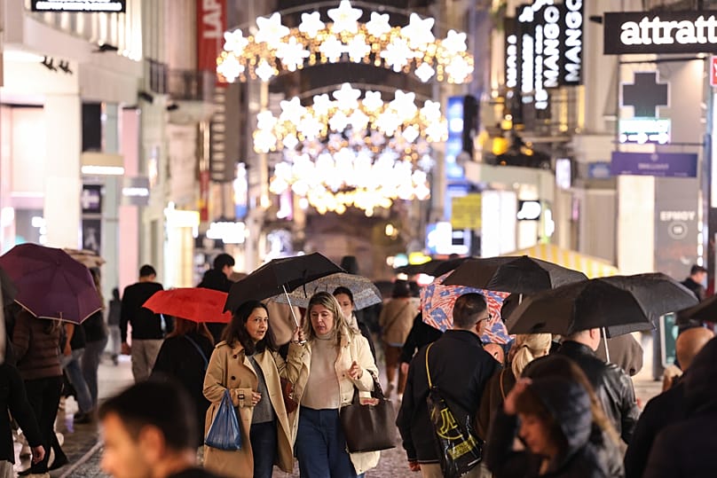 όσμος διασχίζει τους στολισμένους για τα Χριστούγεννα κεντρικούς δρόμους στην Αθήνα