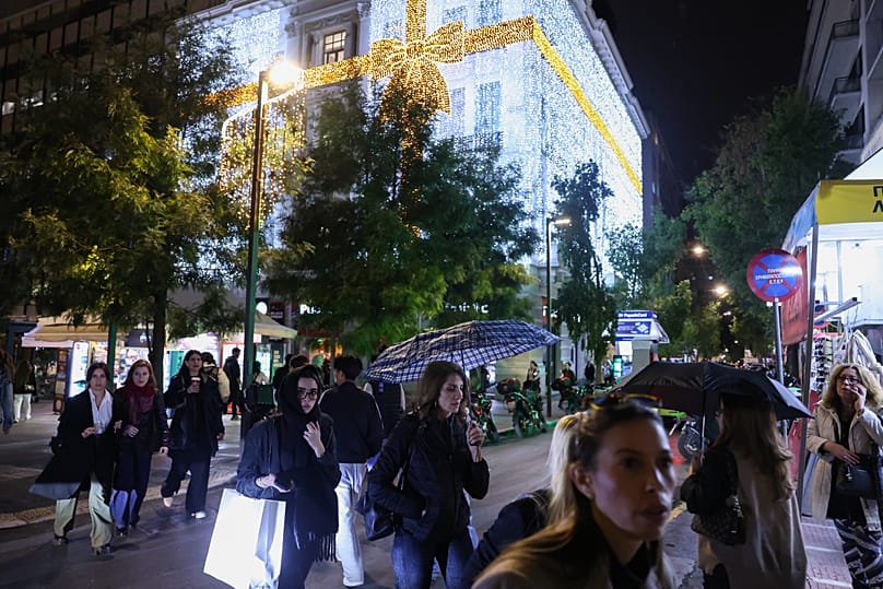 Κόσμος διασχίζει τους στολισμένους για τα Χριστούγεννα κεντρικούς δρόμους στην Αθήνα,