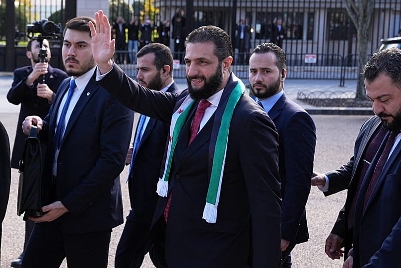 Syria's President Ahmed al-Sharaa waves as he greets supporters outside of the White House following a meeting with US President Donald Trump, 10 November 2025
