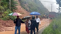 İnsanlar Badulla, Sri Lanka'da şiddetli yağmurun neden olduğu heyelan nedeniyle kapanan otoyolun bir bölümünün önünden geçiyor, 27 Kasım 2025, Perşembe
