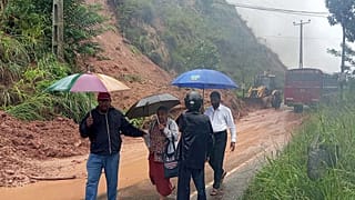 People walk past a section of a highway blocked by a landslide caused by heavy rain in Badulla, Sri Lanka, Thursday, Nov, 27, 2025