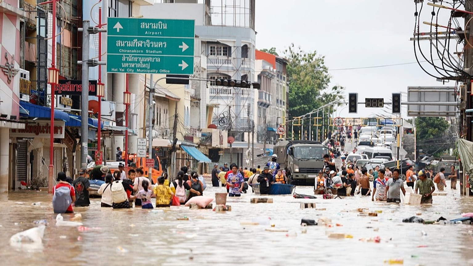 People wade through floodwaters in Songkhla province, southern Thailand, Thursday, Nov. 27, 2025