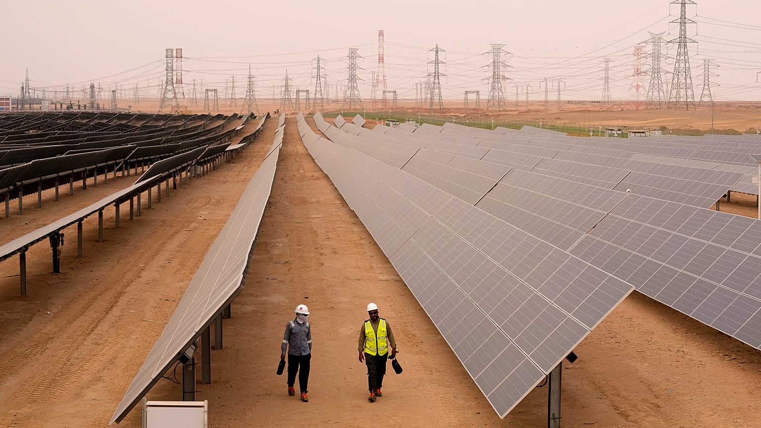 Engineers walk next to solar panels at Benban Solar Park in Aswan, Egypt, Oct. 19, 2022