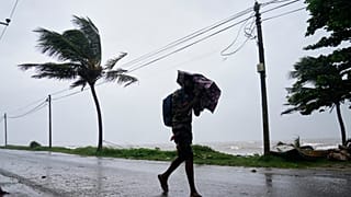 Ένας άνδρας περπατά μέσα σε καταρρακτώδη βροχή στο Κολόμπο, στη Σρι Λάνκα, Παρασκευή 28 Νοεμβρίου 2025