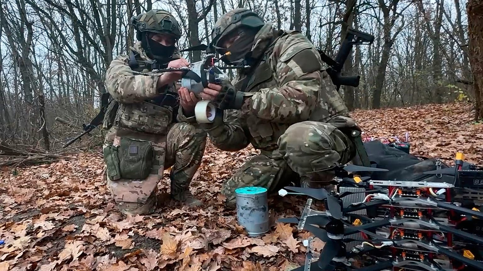 في هذه الصورة، المأخوذة من فيديو نشرته دائرة الصحافة التابعة لوزارة الدفاع الروسية يوم الجمعة، 28 نوفمبر/تشرين الثاني 2025، يُثبت جنود روس متفجرات على طائرة مسيرة في مكان غير 