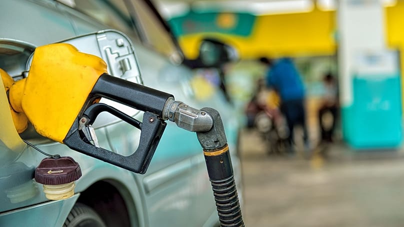 مضخّة وقود موصولة بسيارة في محطة بنزين.