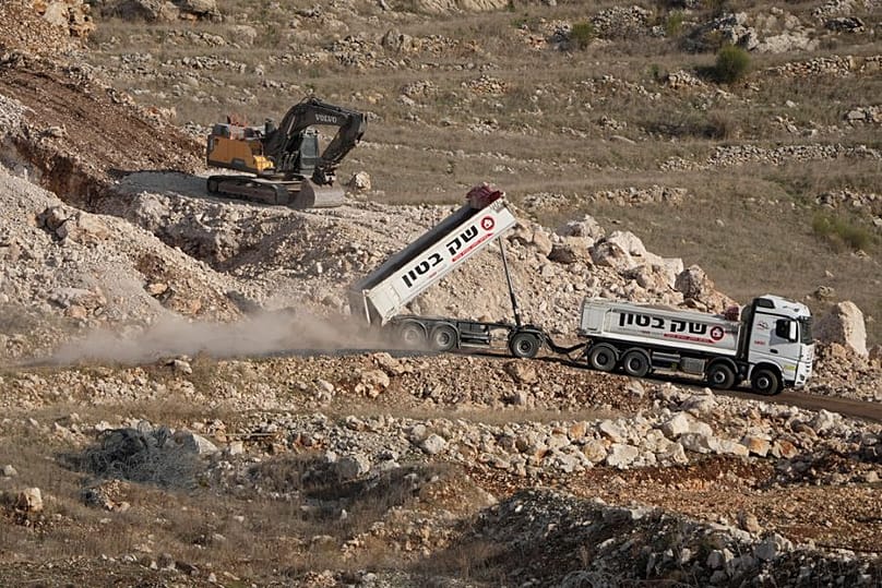  شاحنات إسرائيلية تعمل على شق طريق داخل المنطقة العازلة، في بلدة مجدل شمس، الثلاثاء 17 ديسمبر/كانون الأول 2024. 