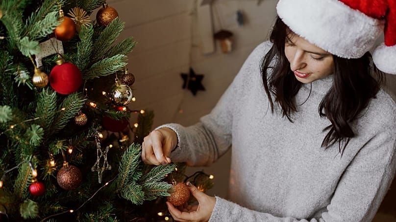 امرأة تزيّن شجرة الميلاد.