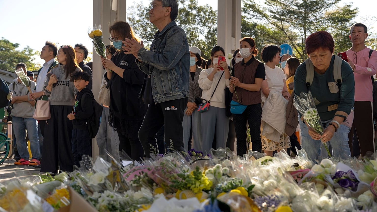 Emberek imádkoznak és virágokat helyeznek el a szerdai halálos tűzvész helyszínénél