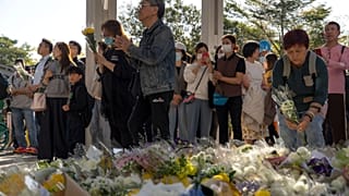 Emberek imádkoznak és virágokat helyeznek el a szerdai halálos tűzvész helyszínénél