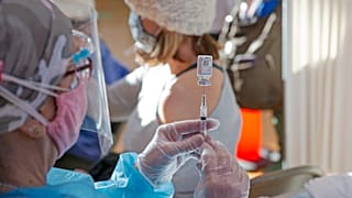 امرأة تُحضّر جرعة من لقاح موديرنا ضد كوفيد-19 في صالة الألعاب الرياضية بمدرسة إنترناشيونال الثانوية في باترسون، نيوجيرسي