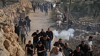 Residenti palestinesi e attivisti fuggono dopo l'intervento dei militari israeliani a Tarkumia in Cisgiordania (28 novembre 2025)