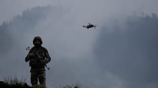 A drone hovers near an Indian soldier