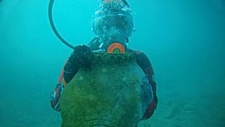 Rusya Bilimler Akademisi Arkeoloji Enstitüsü'nde laboratuvar asistanı olan Kristina Guseynova, elinde eski bir sürahi parçasıyla. 