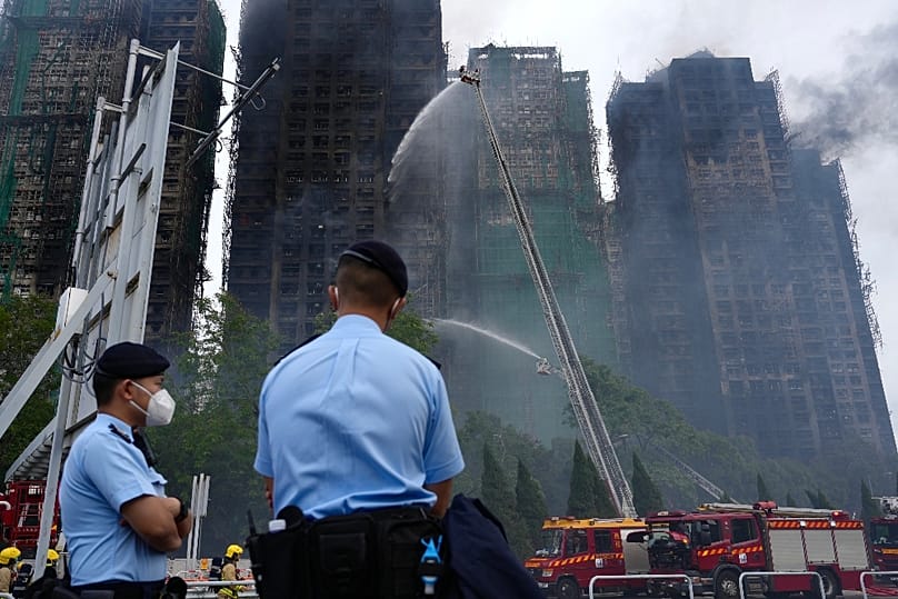 Rendőrök őrzik a hongkongi tűzvész helyszínét, 2025. november 27-én