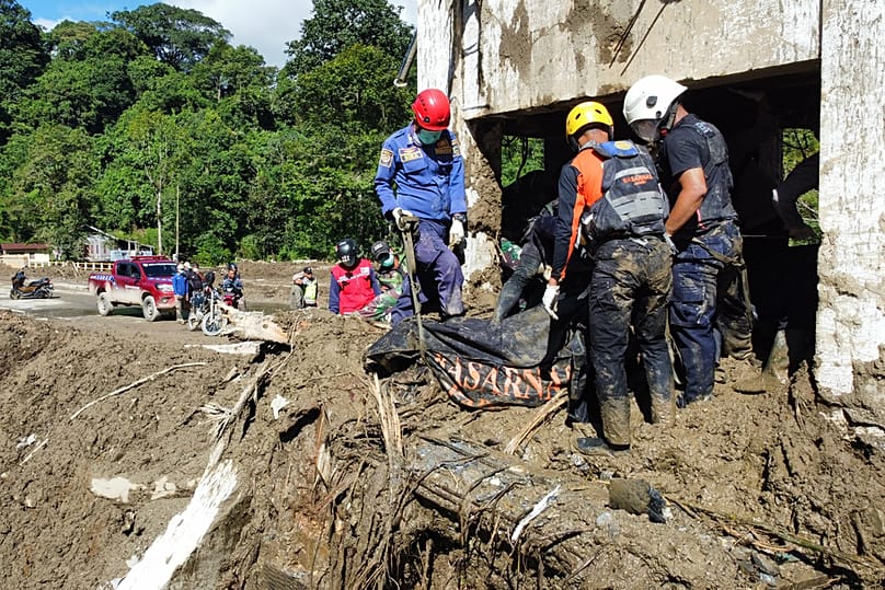Rescuers recover the body of a flood victim in Padang Panjang, West Sumatra, Indonesia, Monday, Dec. 1, 2025. (AP Photo/Ali Nayaka)