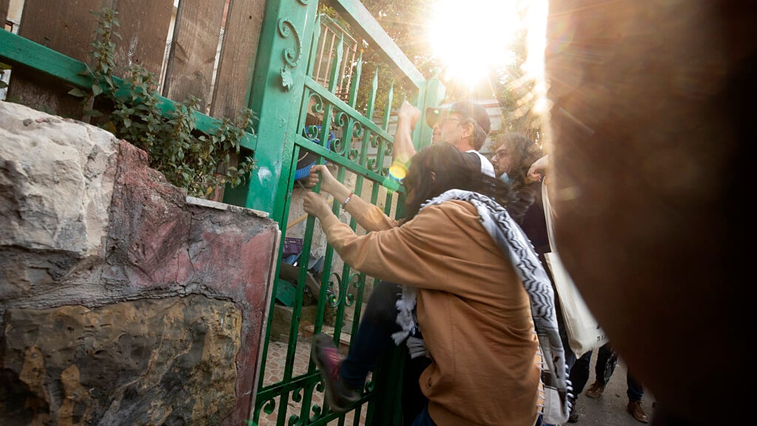 ناشط يهز البوابة الأمامية لمنزل فلسطيني يحتله يهود إسرائيليون خلال احتجاج على الإخلاء القسري للفلسطينيين من منازلهم في حي الشيخ جراح بالقدس ، الجمعة 16 أبريل / نيسان 2021. 