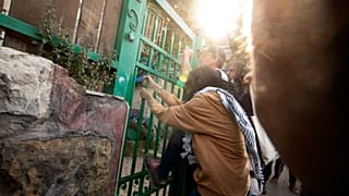 ناشط يهز البوابة الأمامية لمنزل فلسطيني يحتله يهود إسرائيليون خلال احتجاج على الإخلاء القسري للفلسطينيين من منازلهم في حي الشيخ جراح بالقدس ، الجمعة 16 أبريل / نيسان 2021. 