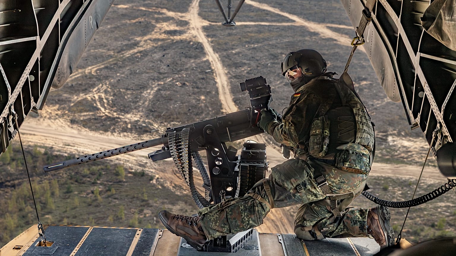 Ein Bordsicherungssoldat beobachtet am Maschinengewehr M3M auf der Heckrampe des CH-53 die Umgebung während der Übung Griffin Lightning 2025 in Litauen, am 10.05.2025