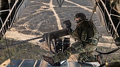 Un soldat de sécurité de bord observe les environs à la mitrailleuse M3M sur la rampe arrière du CH-53 pendant l'exercice Griffin Lightning 2025 en Lituanie, le 10.05.2025