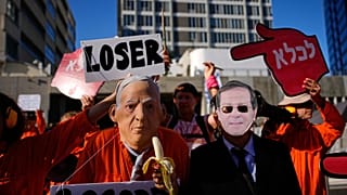 يتظاهر الناس ضد رئيس الوزراء بنيامين نتنياهو خارج محكمة تل أبيب يوم الاثنين 1 ديسمبر 2025، بعد يوم من طلبه العفو من رئيس البلاد وسط محاكمته المستمرة بتهمة الفساد 