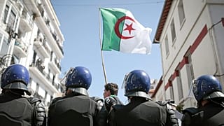 يقف رجال الشرطة على الحراسة بينما يتظاهر الطلاب في الجزائر العاصمة، الجزائر، يوم الثلاثاء 9 أبريل 2019.