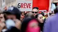 Un manifestant brandit une pancarte « Grève » lors d'une manifestation contre les coupes budgétaires, à Lille,  le jeudi 18 septembre 2025.