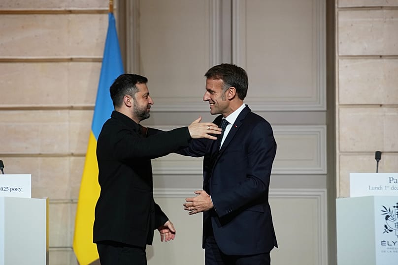 French President Emmanuel Macron, right, and Ukrainian President Volodymyr Zelenskyy hug each other after a joint press conference at the Elysee Palace in Paris, Monday, 1 Dec