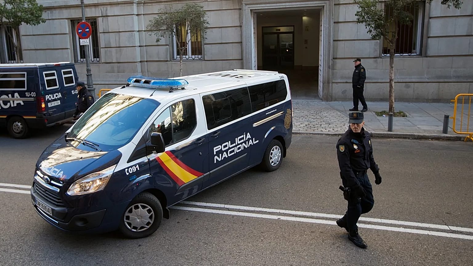 ARCHIVO - Agentes de la Policía nacional española hacen guardia mientras un furgón policial llega al Tribunal Supremo en Madrid.