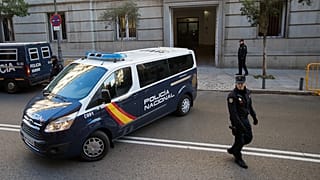 ARCHIVO - Agentes de la Policía nacional española hacen guardia mientras un furgón policial llega al Tribunal Supremo en Madrid.