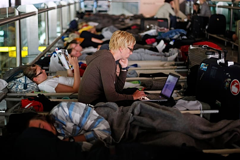 Passengers waiting for a flight to Helsinki rest at Lisbon's Airport on May 10, 2010, as flights were disrupted due to an ash cloud drifting over from Iceland.