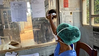 Butembo'daki Matanda Hastanesi'nde bir sağlık görevlisi, bir kişinin vücut sıcaklığını ölçerken, 11 Şubat 2021