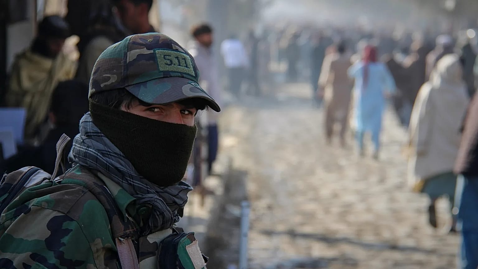 A Taliban policeman looks on as a crowd heads toward a stadium to attend a public execution in the eastern city of Khost, 2 December, 2025