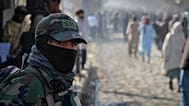 A Taliban policeman looks on as a crowd heads toward a stadium to attend a public execution in the eastern city of Khost, 2 December, 2025