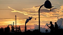 Une raffinerie de pétrole se dresse en arrière-plan tandis que des enfants jouent sur un terrain de basket, à Port Arthur (Texas), mercredi 27 septembre 2017.