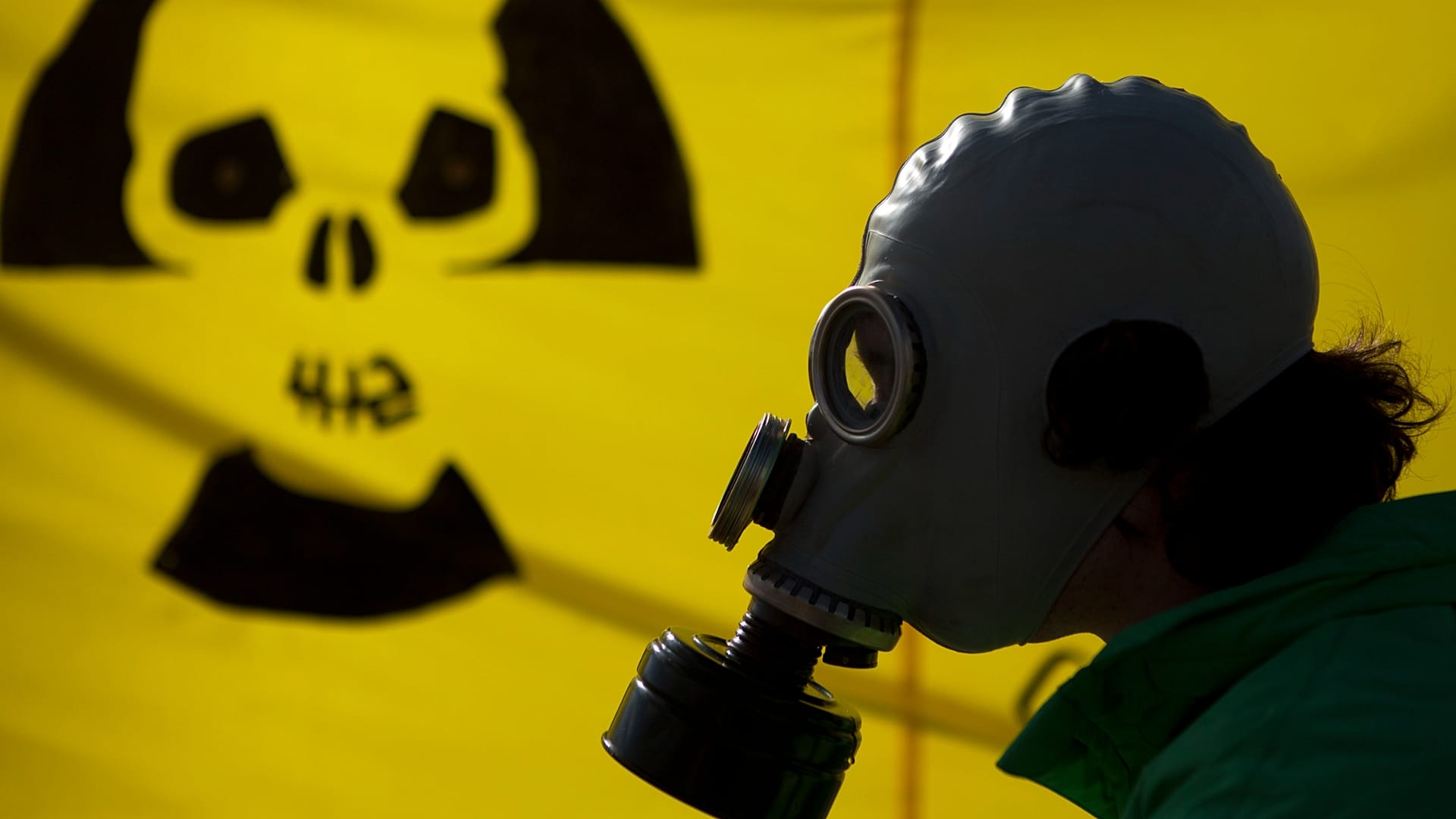Berlino, 26 marzo 2011: un uomo con maschera antigas protesta vicino alla cancelleria contro il nucleare dopo il disastro alla centrale di Fukushima, in Giappone.