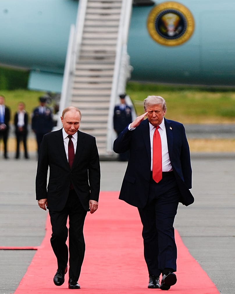 El presidente Donald Trump saluda mientras camina hacia el presidente de Rusia, Vladímir Putin, el 15 de agosto de 2025, en la Base Conjunta Elmendorf-Richardson, Alaska.