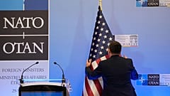 Un homme installe un drapeau américain avant la conférence de presse de l'ancien secrétaire d'État américain Antony Blinken à Bucarest, le 30 novembre 2022.