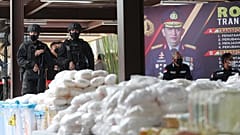 Endonezya polisi, Cakarta'da düzenlenen bir basın toplantısı sırasında el konulan ve "Shabu" olarak bilinen yasa dışı uyuşturucunun yanında beklerken, 28 Nisan 2021